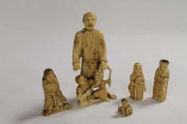 A nineteenth century Japanese ivory figure depicting two men clutching a vine, together with four
