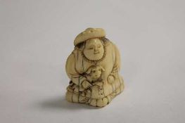 A nineteenth century ivory netsuke depicting a man with a small dog, height 4.8 cm. CONDITION