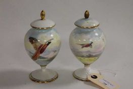 A pair of Minton hand painted miniature urns, decorated with pheasants in flight, signed by A.