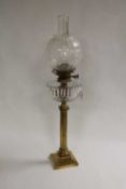 A nineteenth century brass oil lamp with glass reservoir and shade, height 78 cm. CONDITION