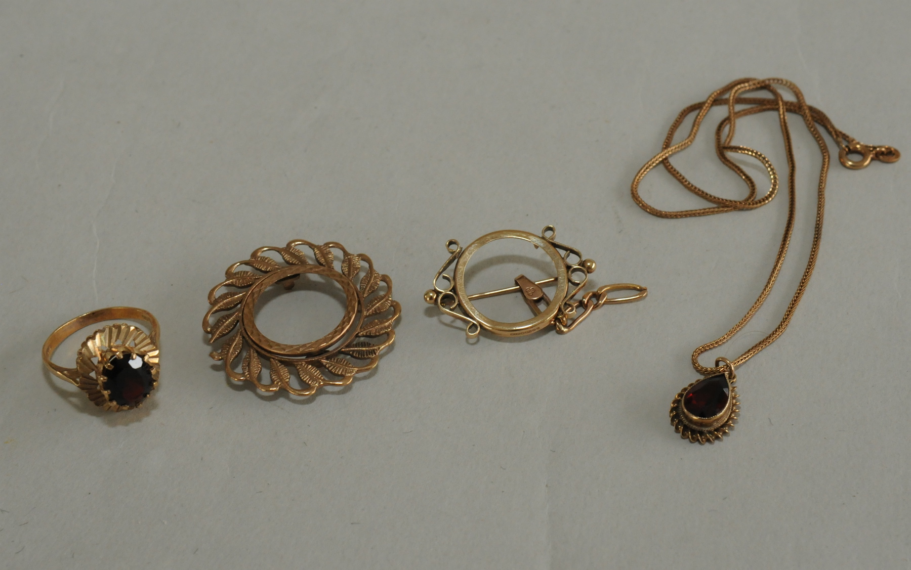 Two sovereign mounts; a garnet ring & a similar pendant, all 9ct gold.