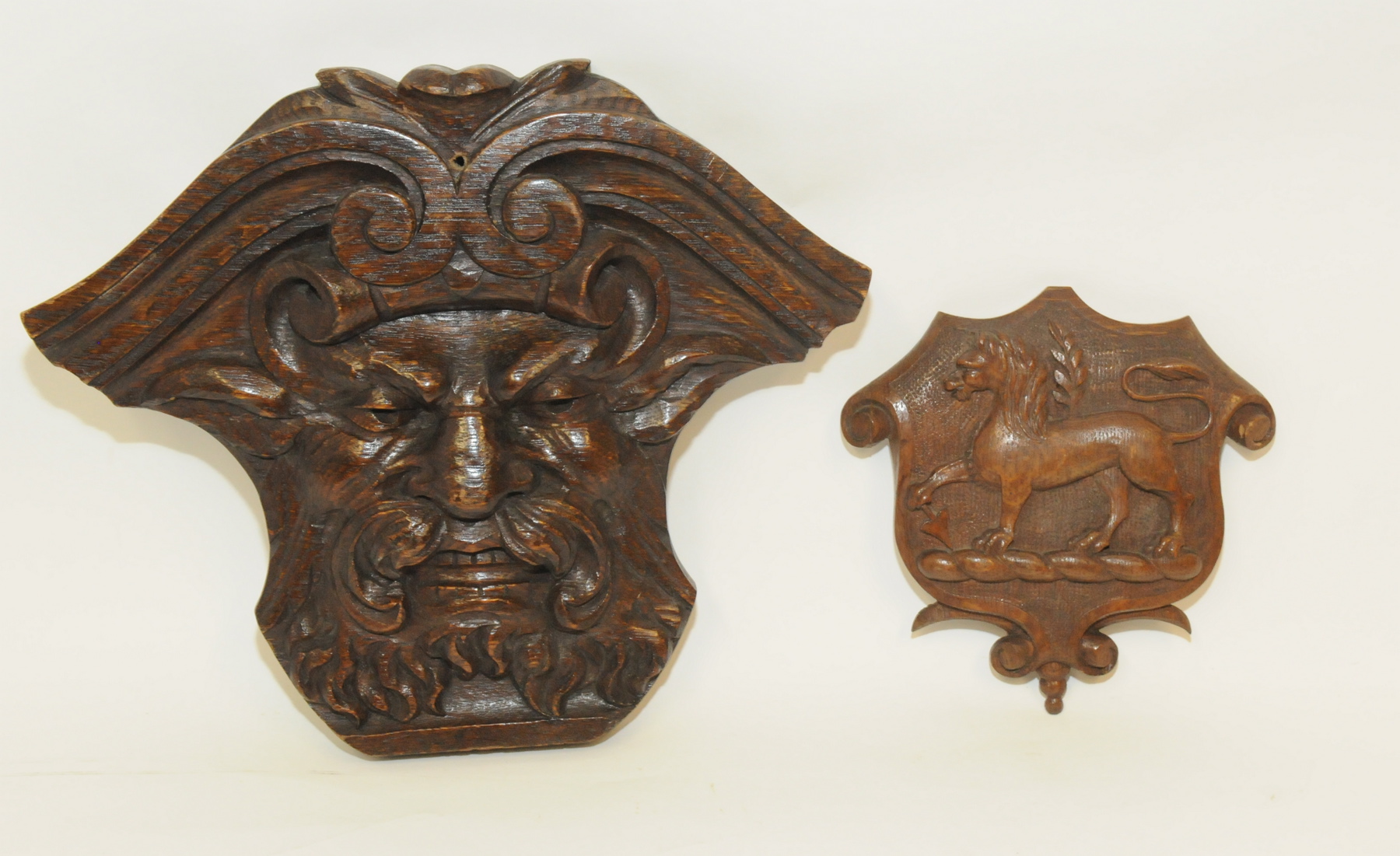 Antique carved oak crest of shield form with lion, arrow & branch, 7" high; also a carved wall