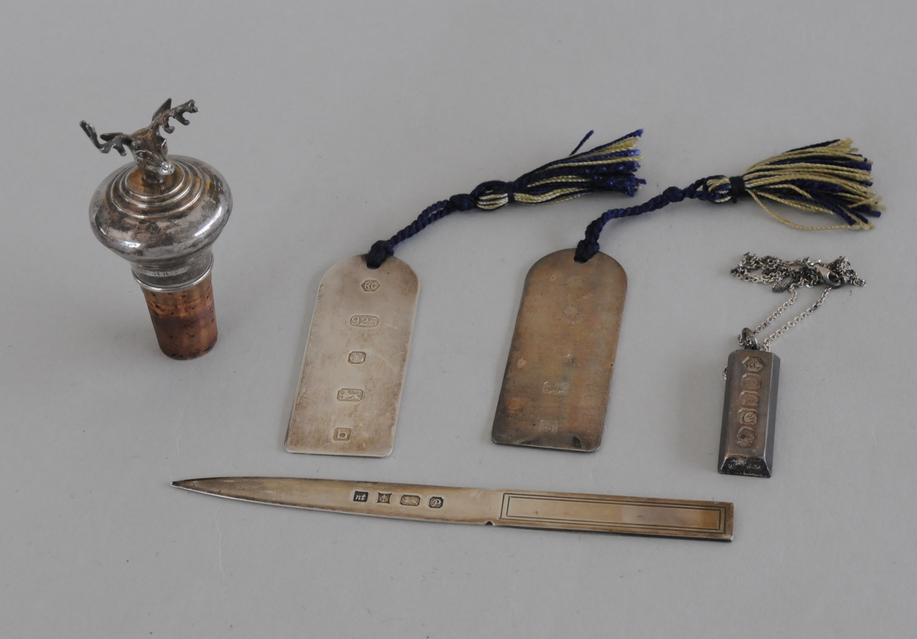 Two silver bookmarks; a paperknife; an ingot pendant & a mounted bottle cork with stag's head, 4 oz.