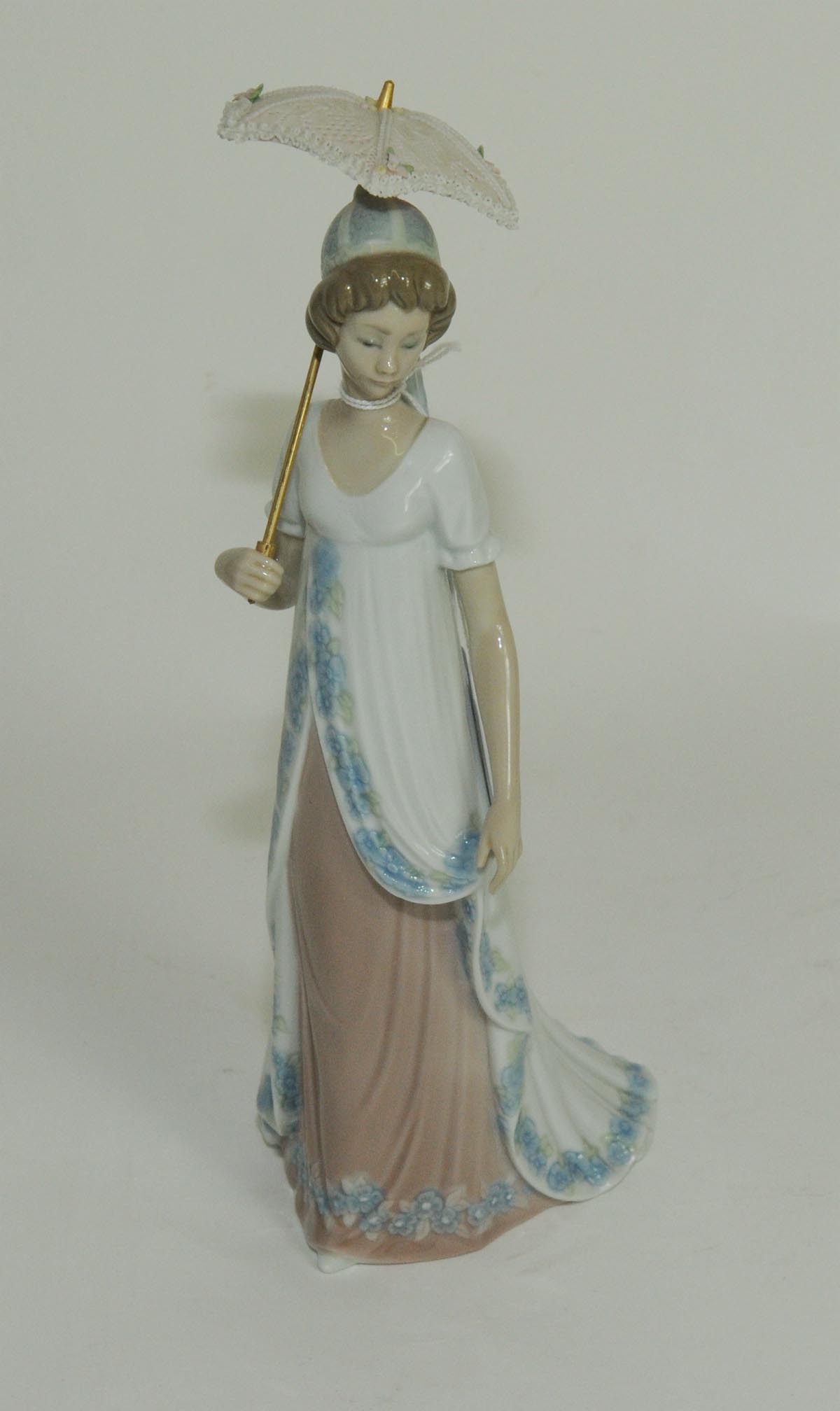 Lladro porcelain figure of a girl in long flowing dress carrying a parasol, 10½" high.