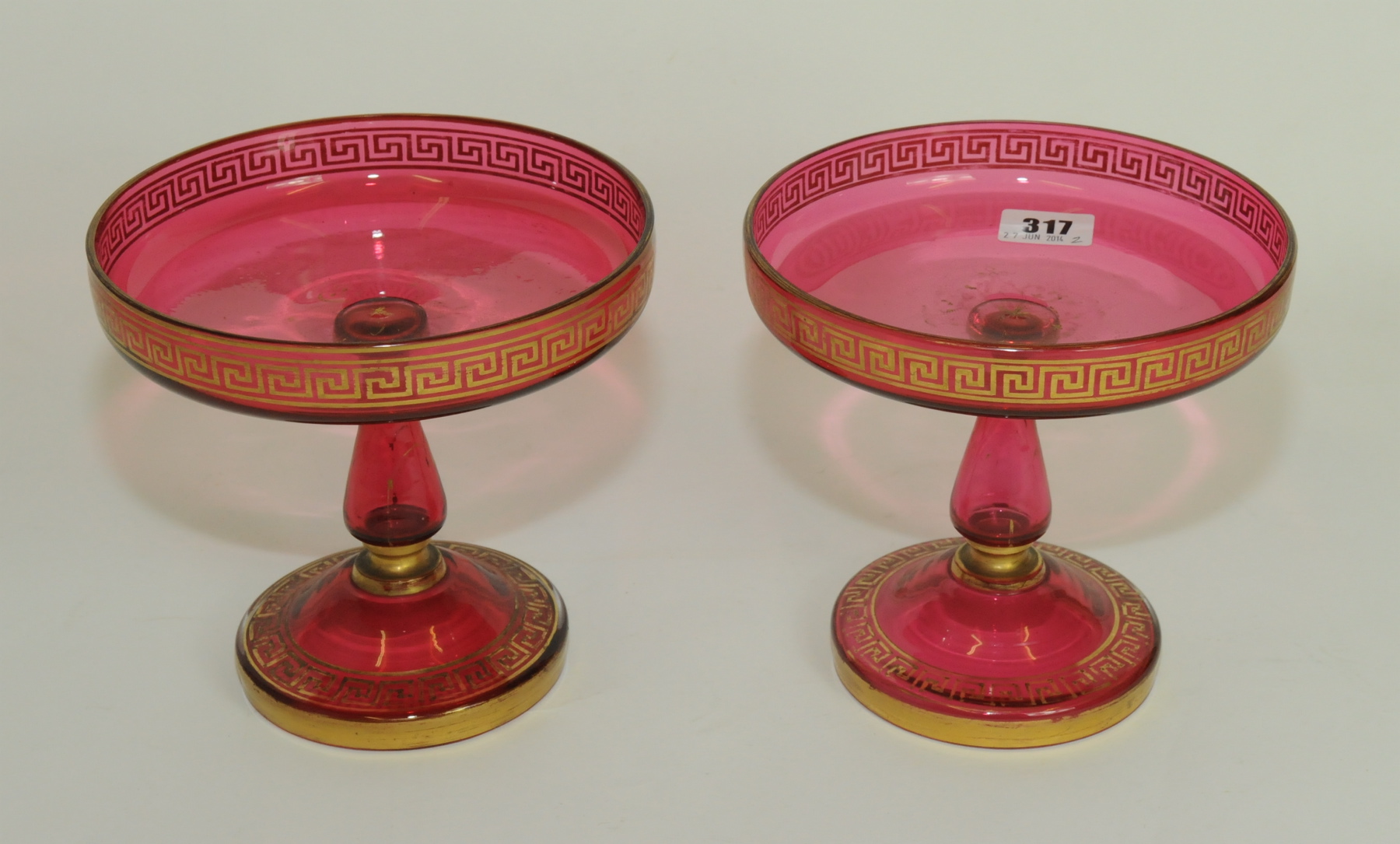 Pair of 19th century cranberry glass comports, the shallow circular tops on baluster column &