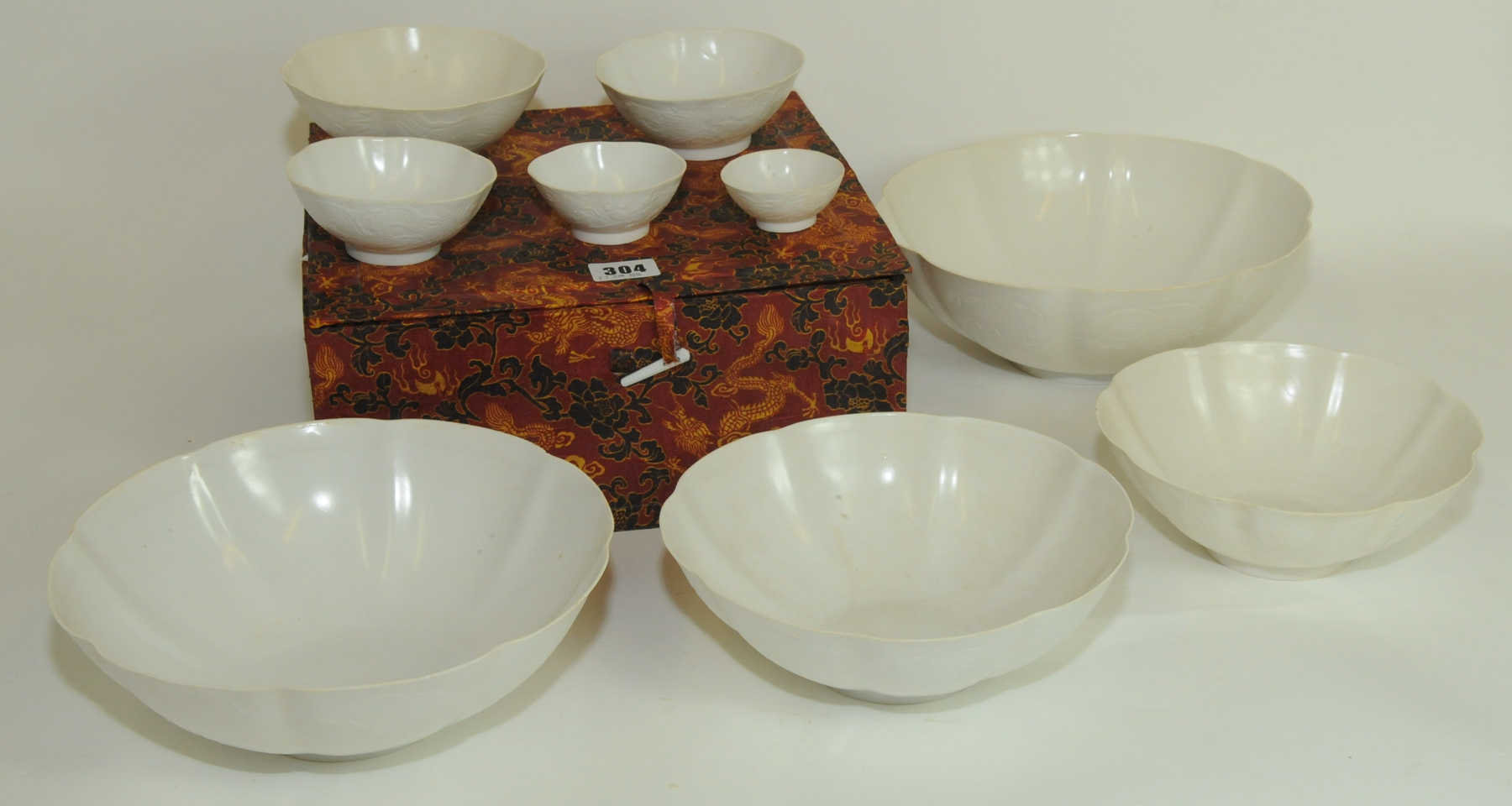 Late 20th century Chinese nest of eight graduated lobed white porcelain bowls with incised scrolling