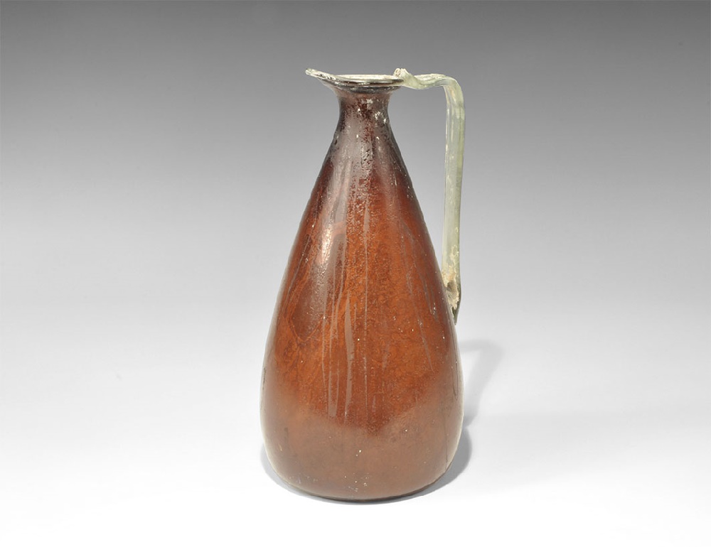 Islamic Fatimid Style Aubergine Glass EwerAn undated archaistic piriform ewer with pontil base in