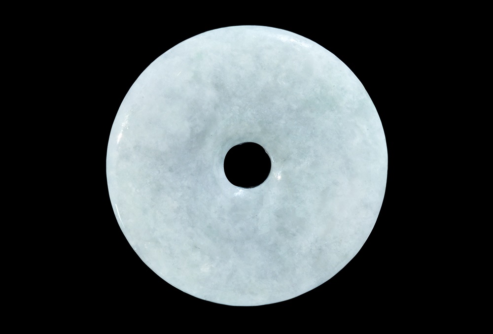 Chinese Jade Polished Disc20th century AD. A carved disc with central hole, chamfered edges. 28