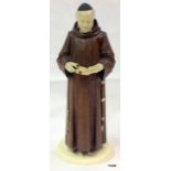 A carved wooden figure of a monk with ivory hands, head and feet 19cm high