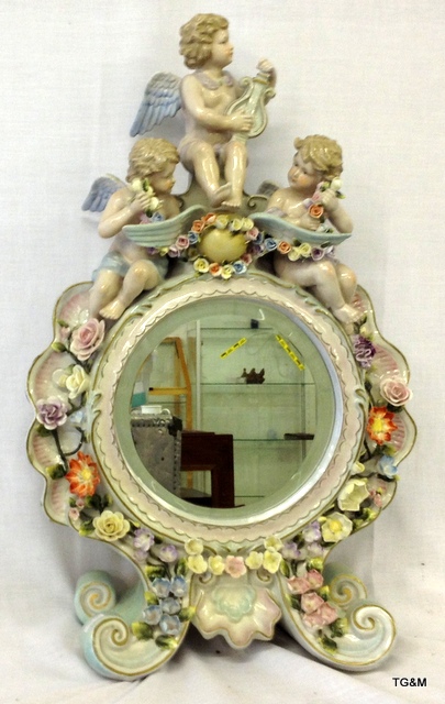 A Porcelain cherub and flower mantle mirror 55cm high 36cm wide