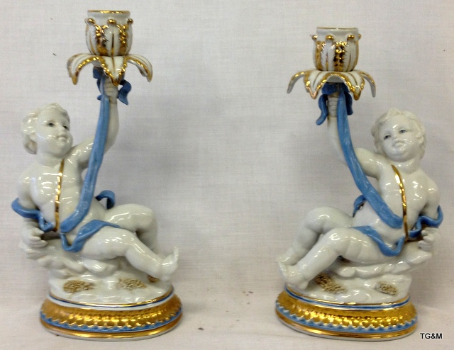 A pair of Porcelain cherub candle sticks 30cm high 16cm wide