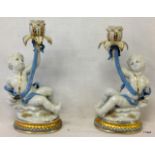A pair of Porcelain cherub candle sticks 30cm high 16cm wide