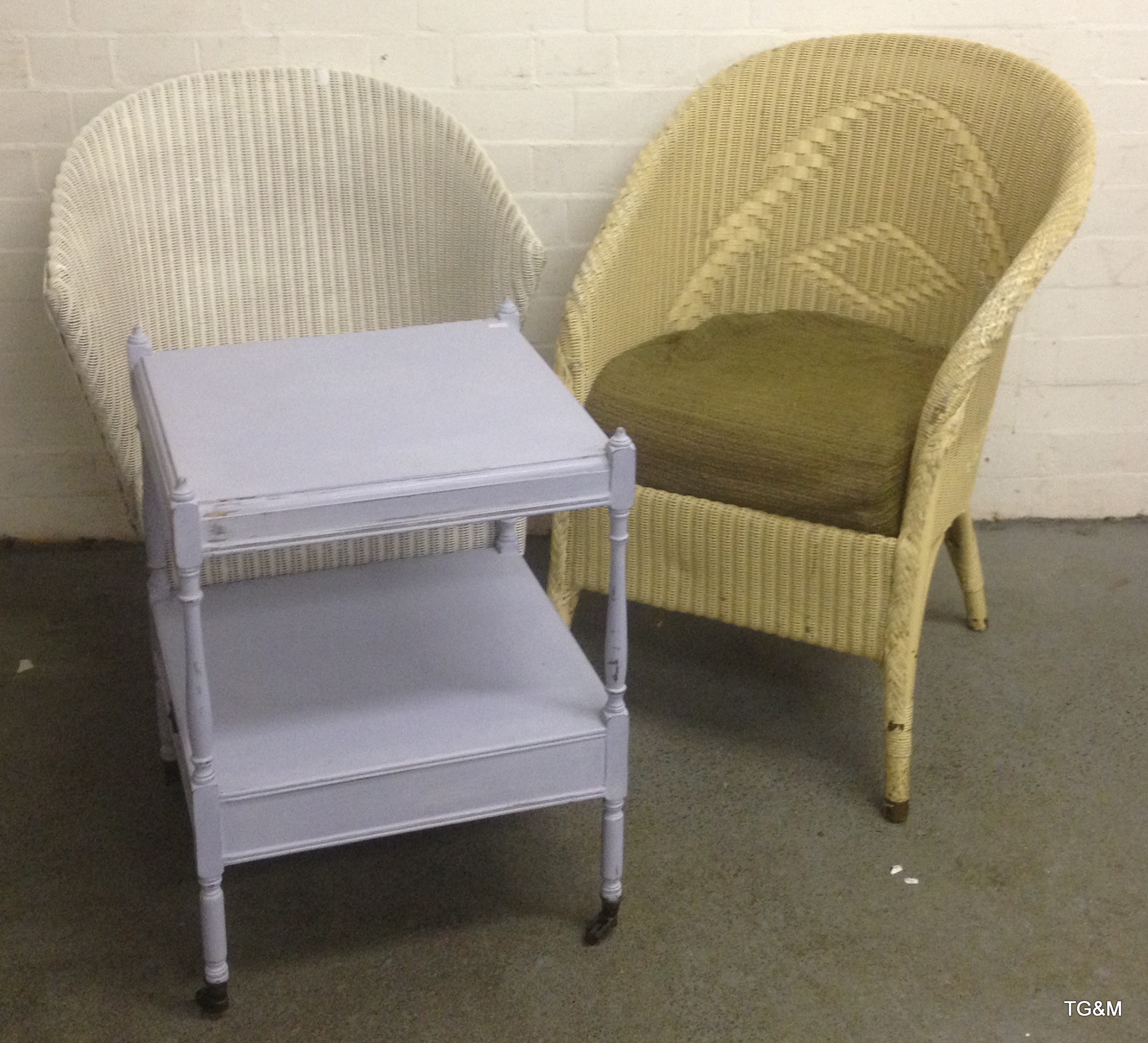 Two wicker chairs and a painted two tier table