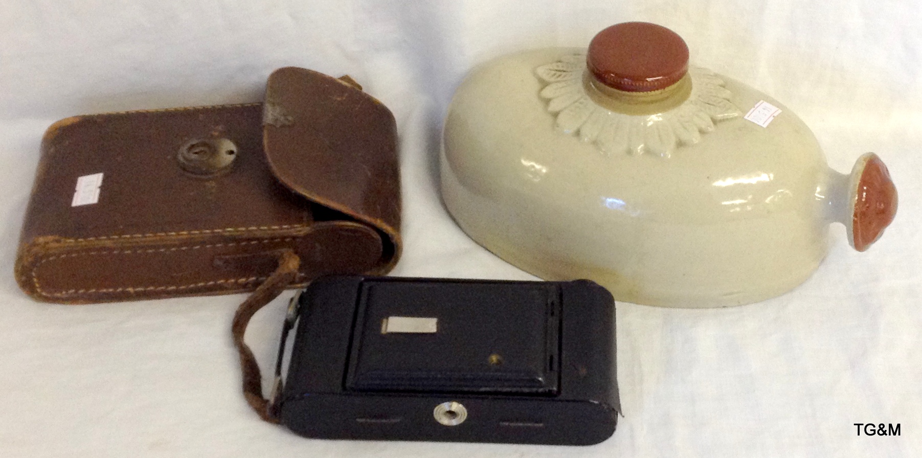 Victorian hot water bottle, vintage bellows and a camera