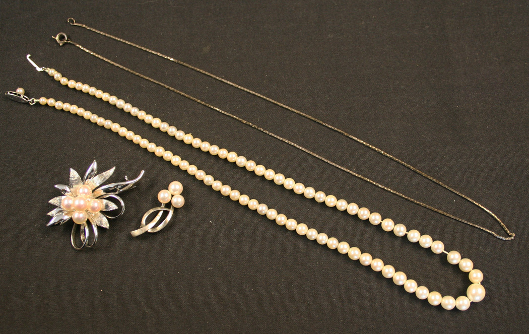 A graduated cultured pearl necklace, with box and Mikimoto booklet, a pendant, mounted with three