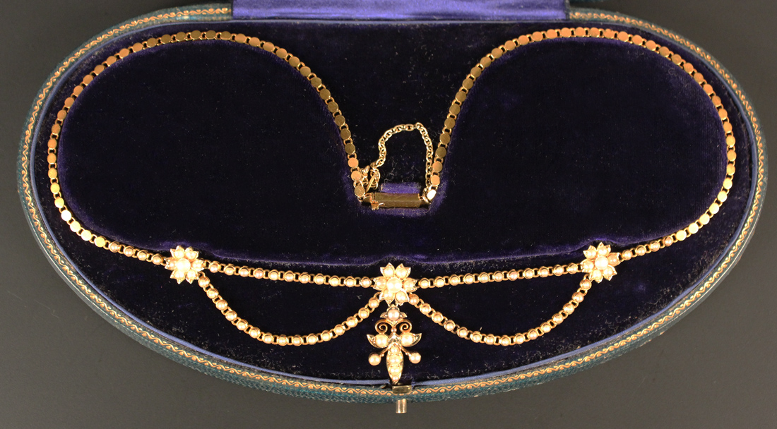 A gold and half pearl set necklace, the front with three flowerhead shaped motifs and a trefoil