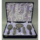 A modern silver dressing table set, embossed with masks and foliate scrolls, Birmingham 1976,