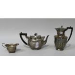 An Edwardian silver teapot and milk jug, of cushion form with reeded and gadrooned decoration,