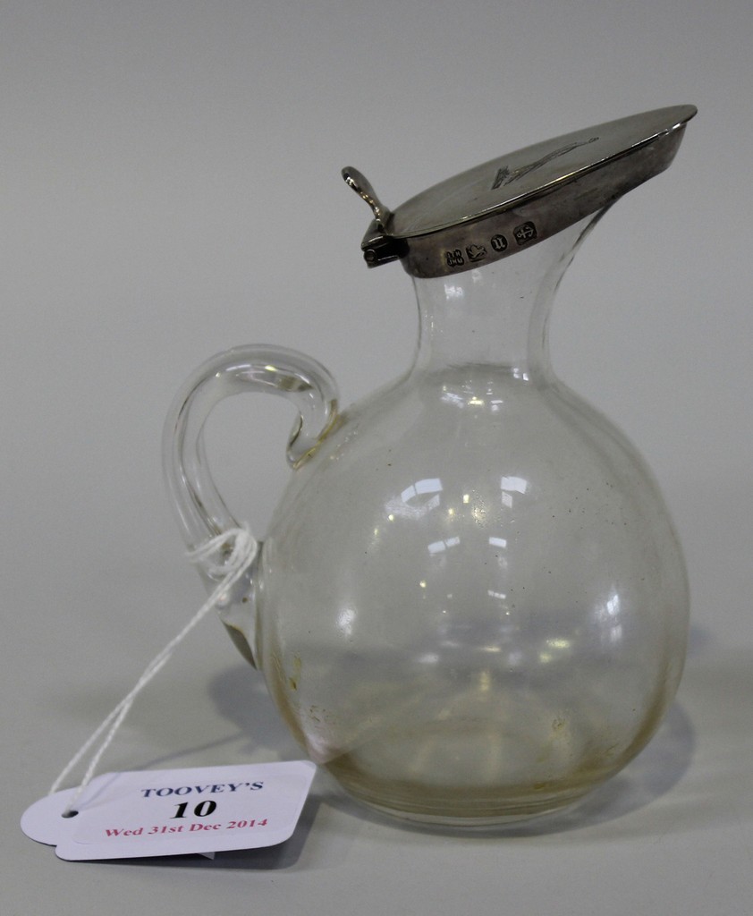 A Victorian silver mounted glass whisky tot, the clear glass globular body and loop handle fitted