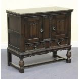 A 20th Century oak side cabinet, fitted with a pair of panel doors with linenfold decoration above