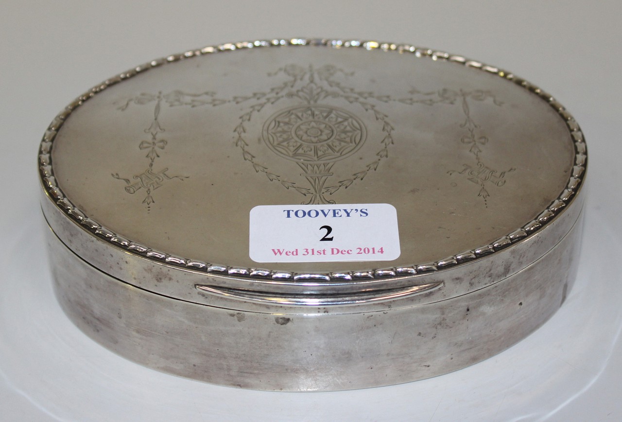 An Edwardian silver oval jewellery box, the hinged lid engraved with a circular floral pendant