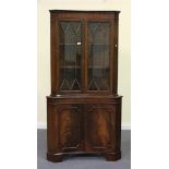 A late 20th Century George III style mahogany inverted bowfront corner display cabinet, fitted