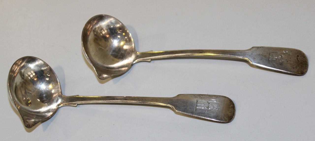 A pair of early Victorian Irish silver Fiddle pattern sauce ladles, each bowl with pouring lip,