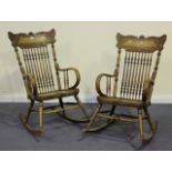 A pair of early 20th Century elm and ash rocking armchairs with carved bar and turned spindle