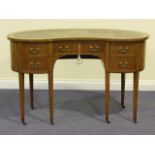 An Edwardian satinwood and crossbanded kidney shaped writing table, the inset gilt-tooled leather