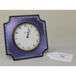 A George V silver and lilac enamelled cut cornered square bedside timepiece, the circular dial