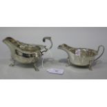 A George V silver sauce boat with foliate capped flying scroll handle, on scallop shell shouldered