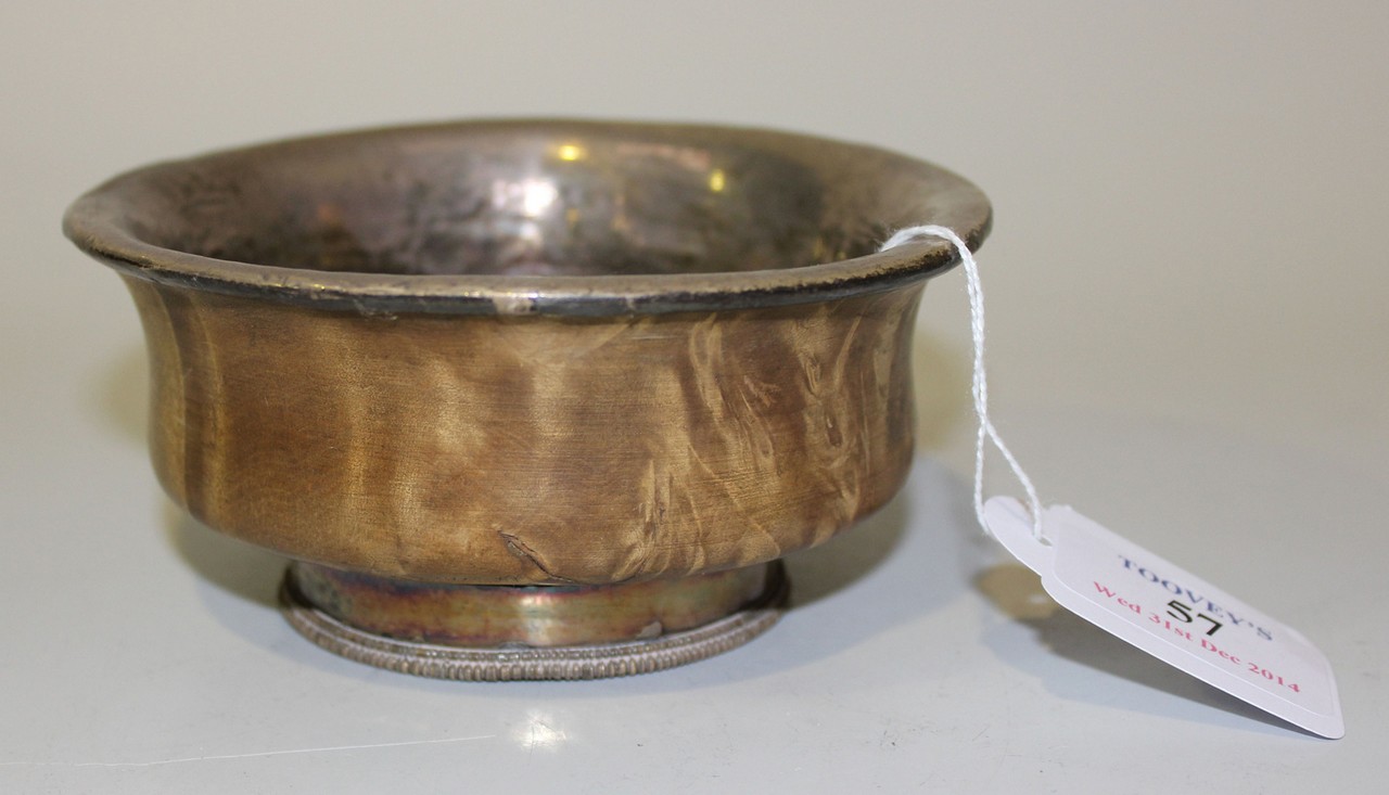 A Tibetan white metal lined wooden bowl, late 19th/early 20th Century, on a similarly mounted