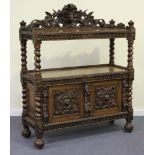 A late Victorian oak two-tier buffet, profusely carved with animal masks, flowers and scrolls, the