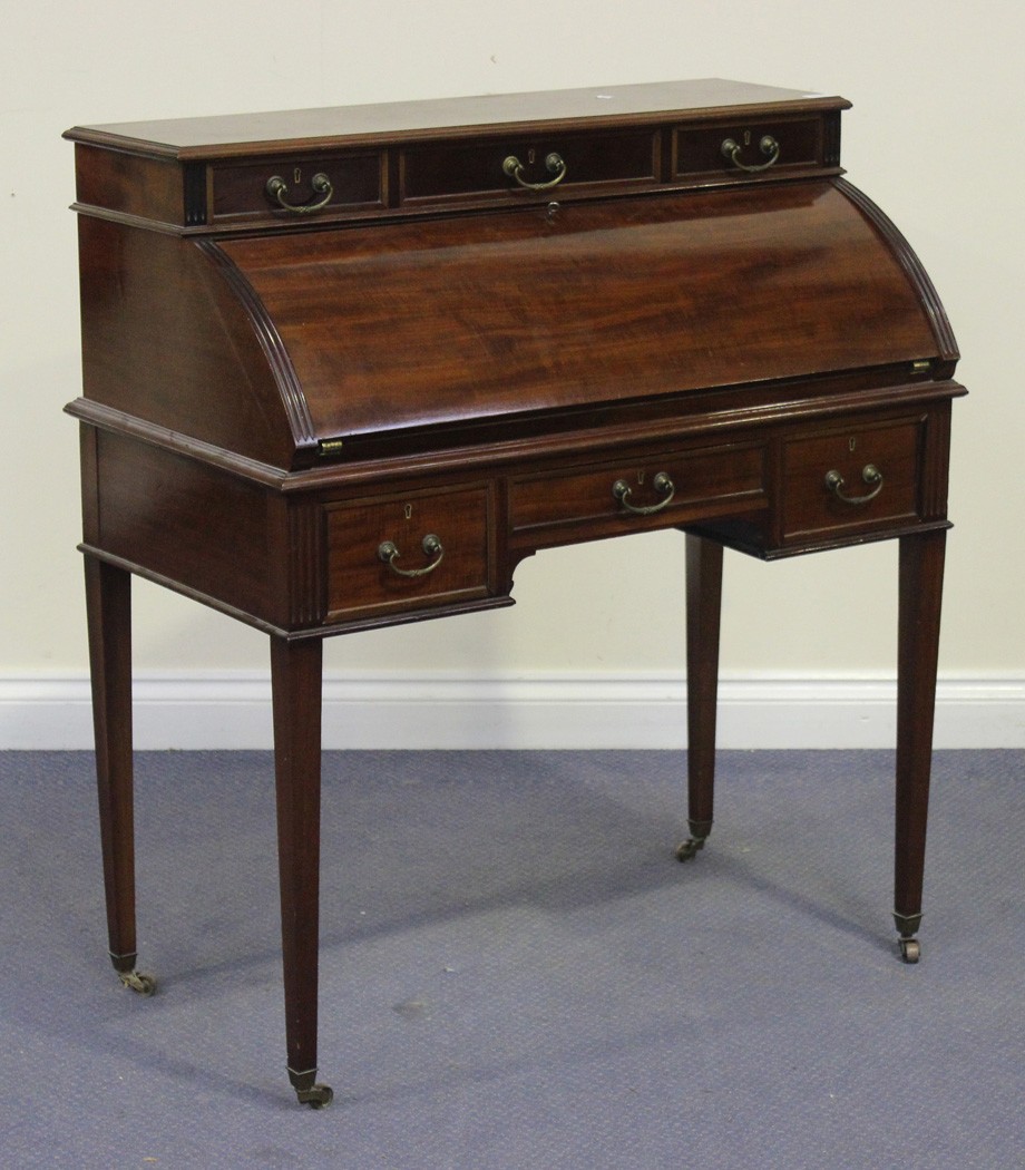 An Edwardian mahogany lady`s writing desk, fitted with six drawers and a fall flap enclosing a
