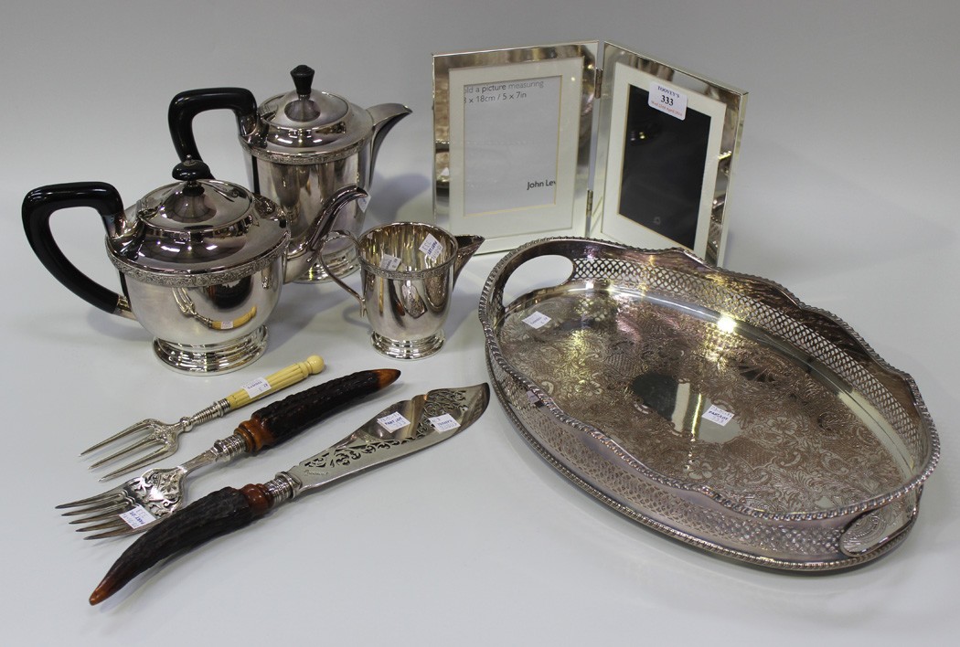 A plated three piece tea set, a plated oval gallery tray, a pair of plated and antler handled fish