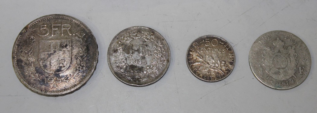 A large collection of foreign coins, including Switzerland five francs 1954B and one franc 1945,