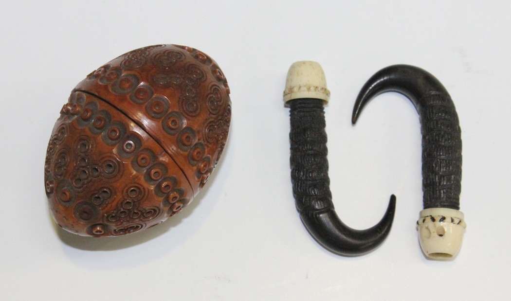 A 19th Century carved coquilla nut box in the form of an egg, together with a pair of carved horns.