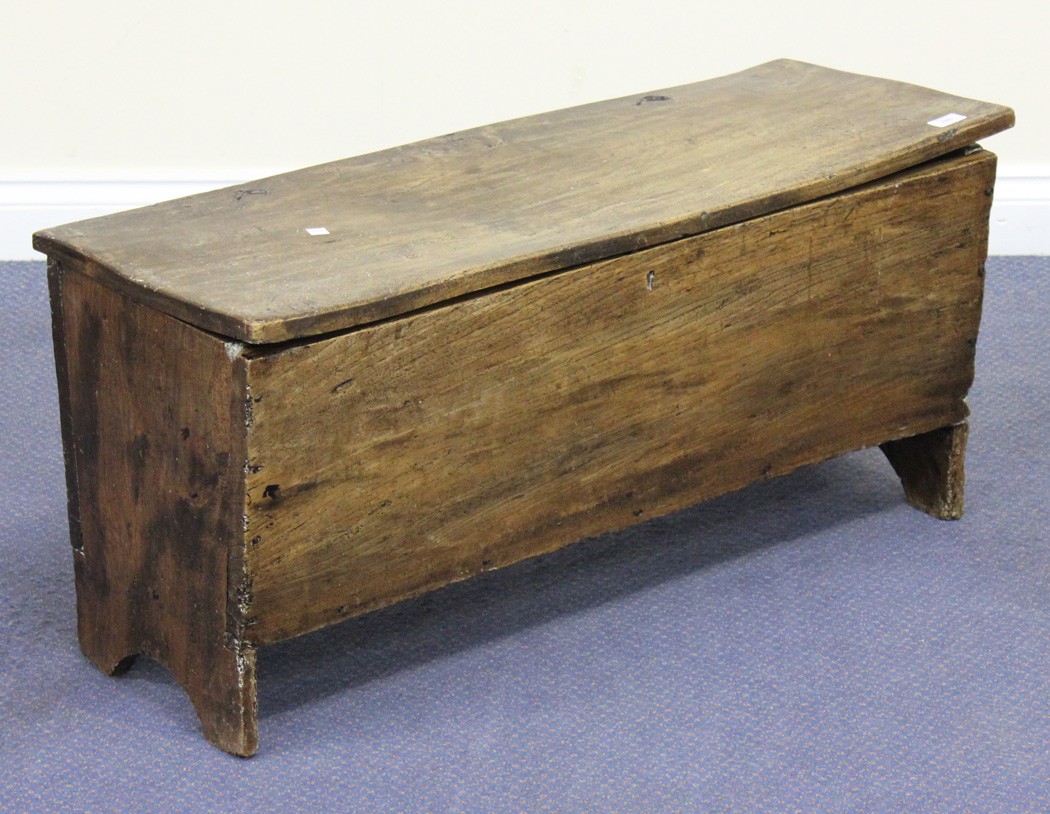A 17th Century style stained elm six plank coffer, the hinged lid above shaped sides, width approx