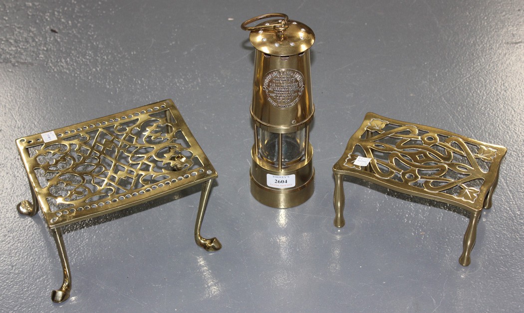 A miner`s lamp by Protector Lamp and Lighting Co, together with two brass footmen.