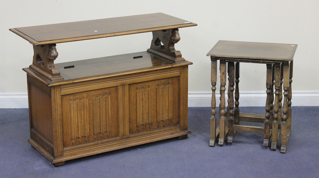 A 20th Century oak monk`s bench, with linen-fold decoration, on stile supports, together with a nest