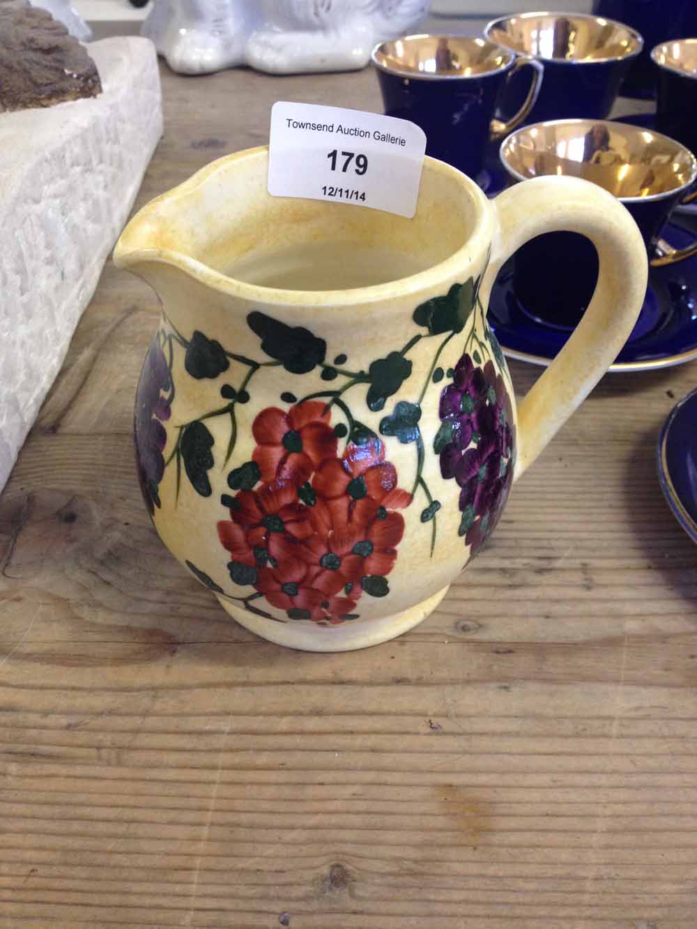 An early E.Radford Burslem Pottery jug with red & purple hanging flowers on yellow ground, 10.5cm