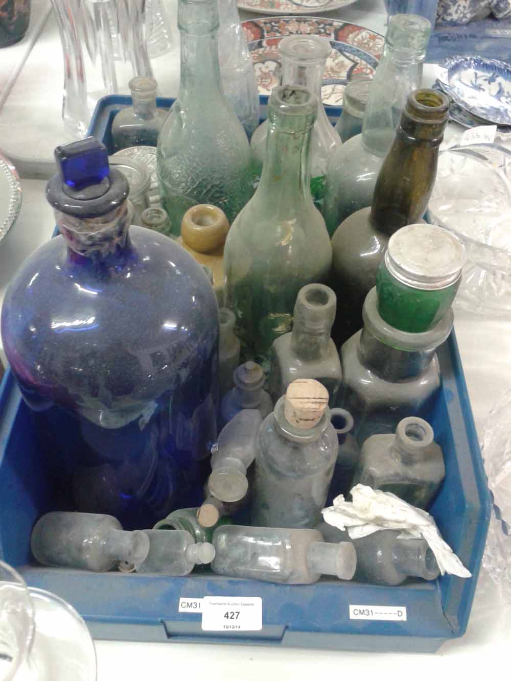 A box of old glass bottles of mixed sized.