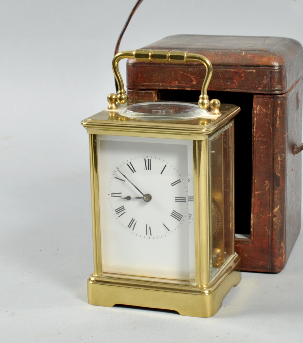 A late 19c French carriage clock in a glazed brass corniche type case. The rectangular white enamel