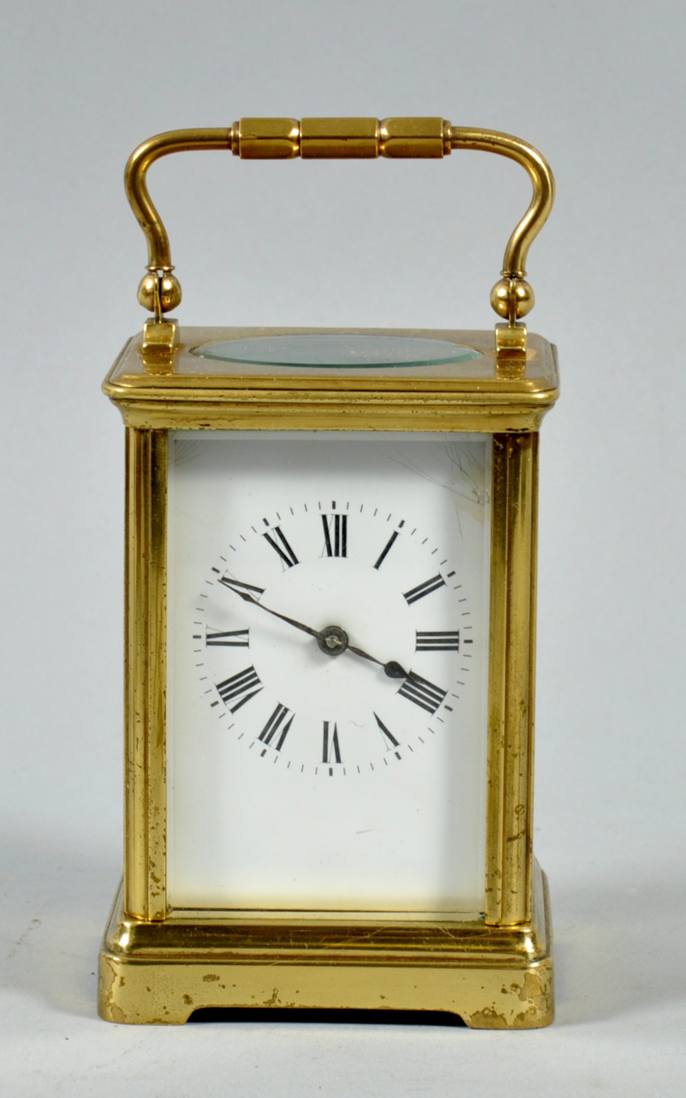 A late 19c French carriage clock in glazed brass corniche type case. The rectangular white enamel