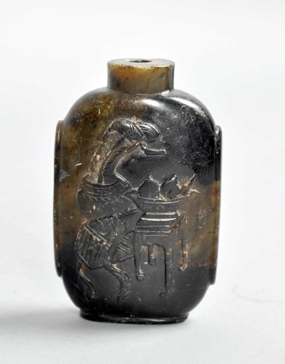 A collection of three Oriental snuff bottles, one carved with domestic decorative objects, an amber