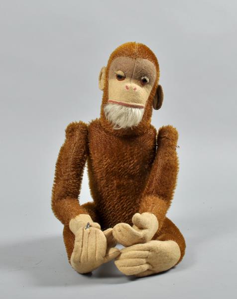 An early 20c soft toy monkey, with articulated limbs, straw filled and with swinging hooks to the