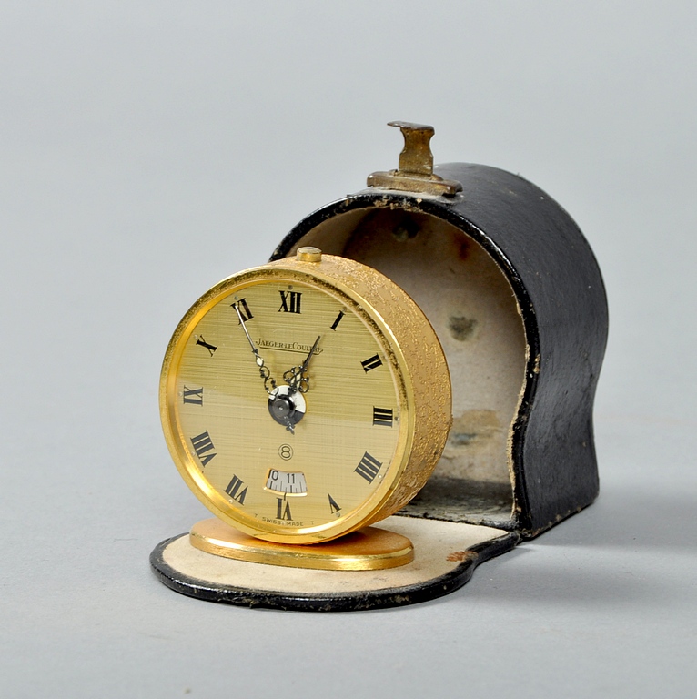 A 1960`s Jaeger Le Coultre travelling alarm clock in circular gilt case on oval stand. The case