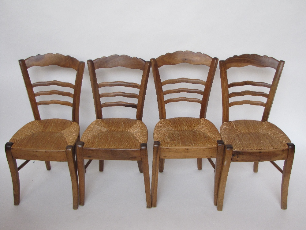 A set of four 19th Century French walnut ladderback chairs with rush seats (4).