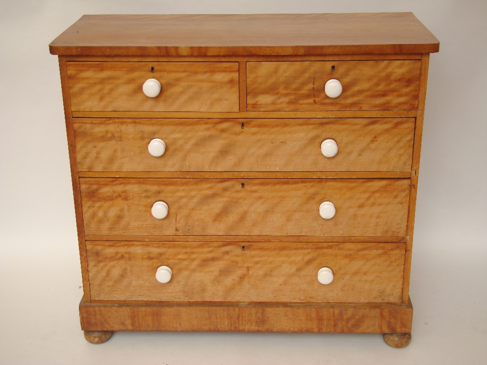 A mid Victorian satin birch chest of drawers, with two short and three long drawers with ceramic