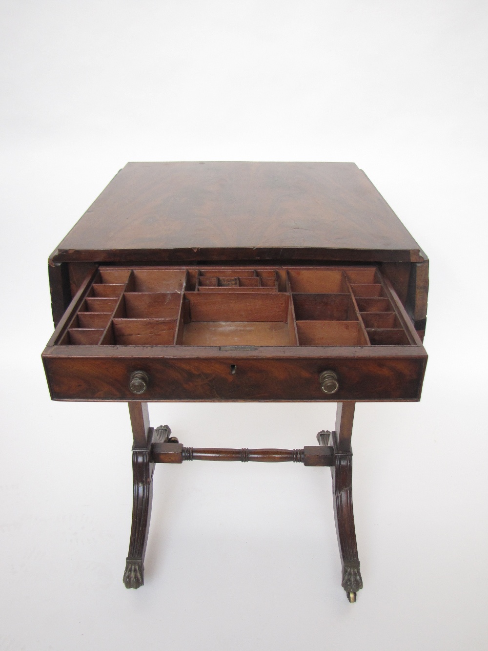 A Regency mahogany work table, the figured mahogany top with two hinged flaps over a frieze drawer